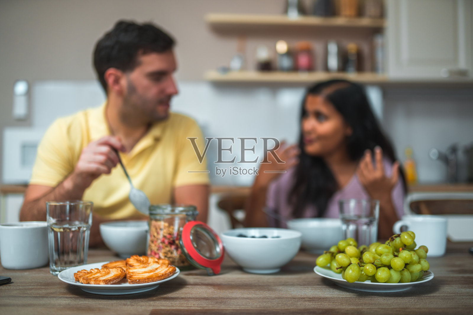 不同的夫妇在早餐时谈话。照片摄影图片