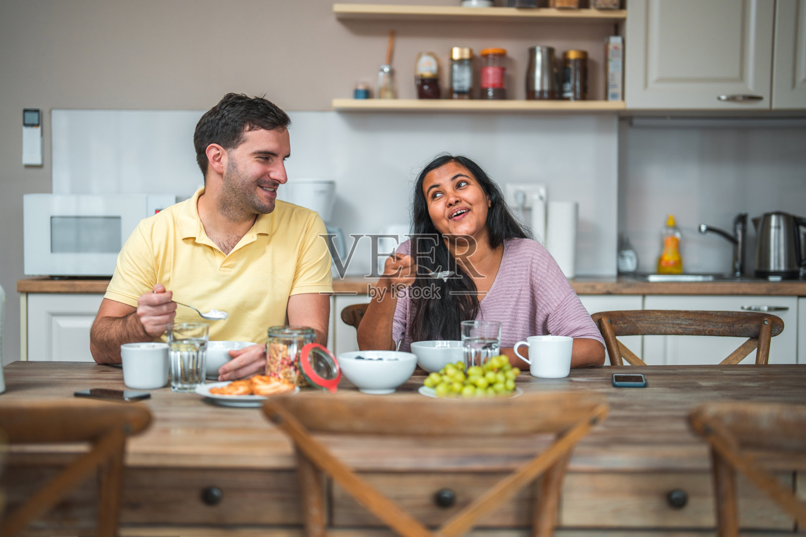 多种族的夫妻在早餐时进行有趣的对话。照片摄影图片