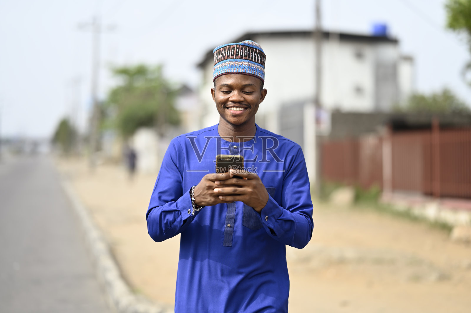 年轻英俊的非洲商人穿着传统服装对社交媒体趋势做出反应。年轻有野心的商人。本空间照片摄影图片