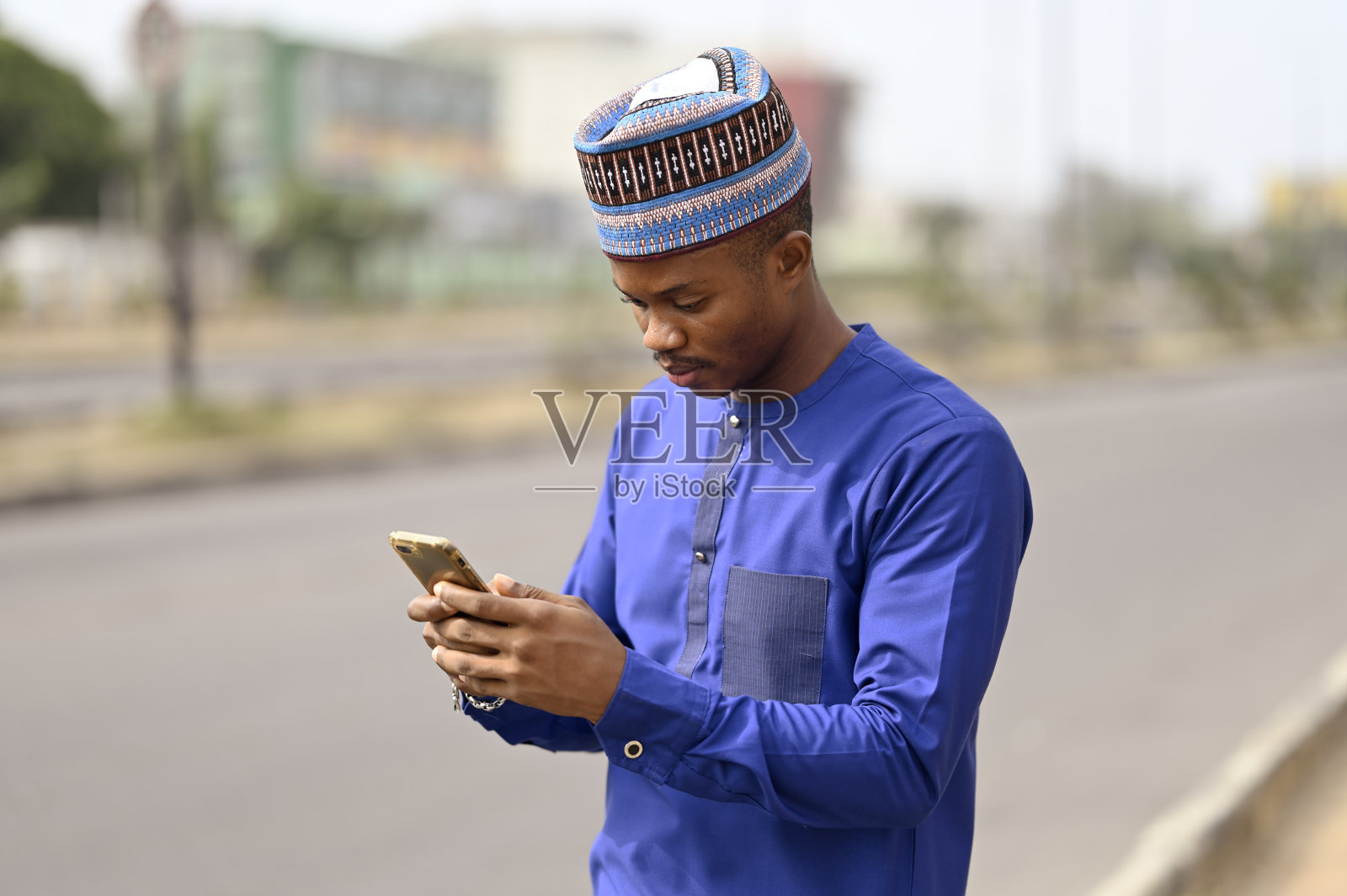 年轻的非洲人在高速公路旁等待时发短信聊天照片摄影图片