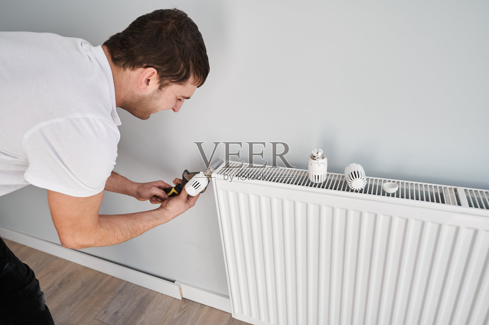 正在装修的公寓正在安装暖气片。照片摄影图片