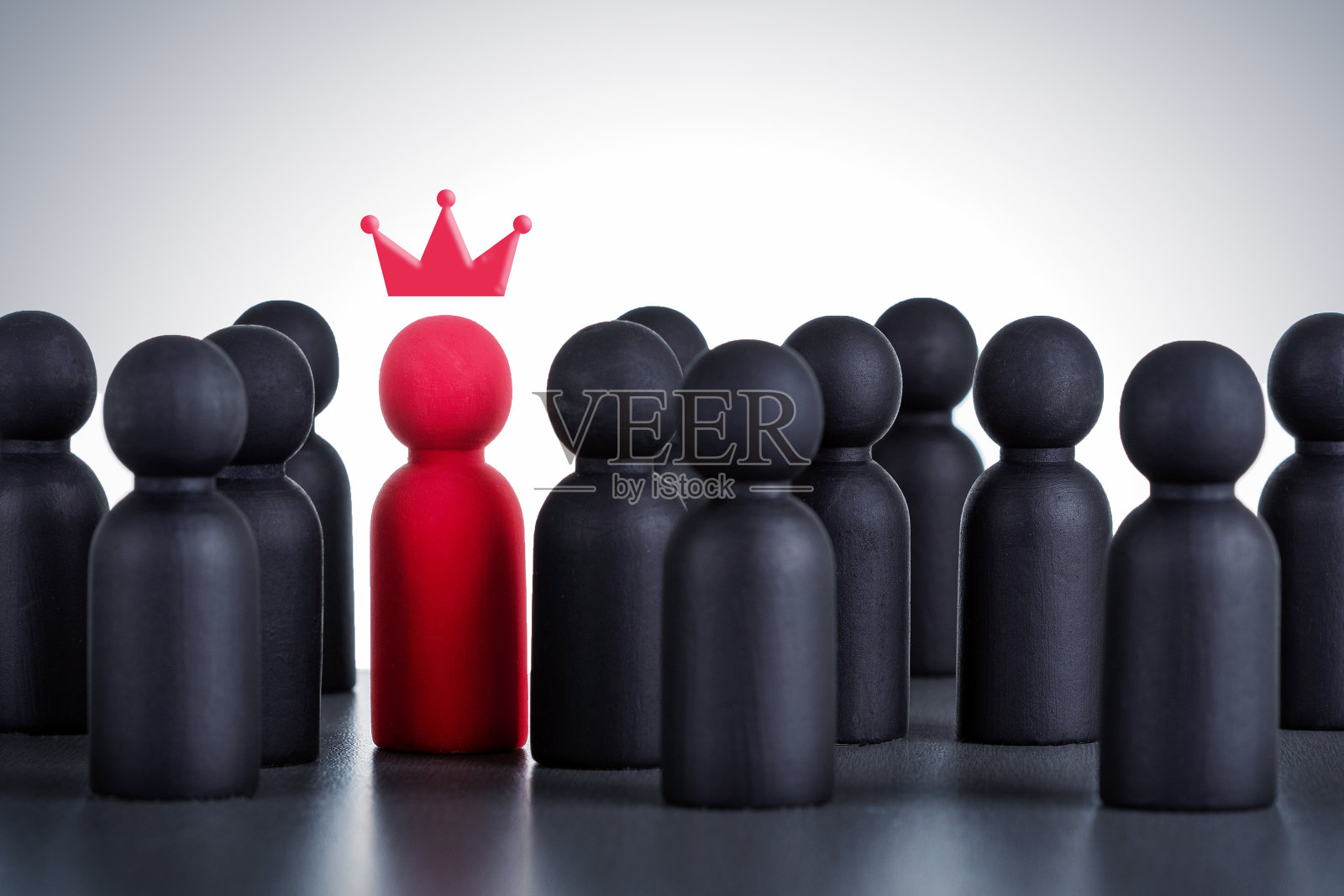 木制人物与彩绘皇冠。成功的商业团队领导者的概念。照片摄影图片