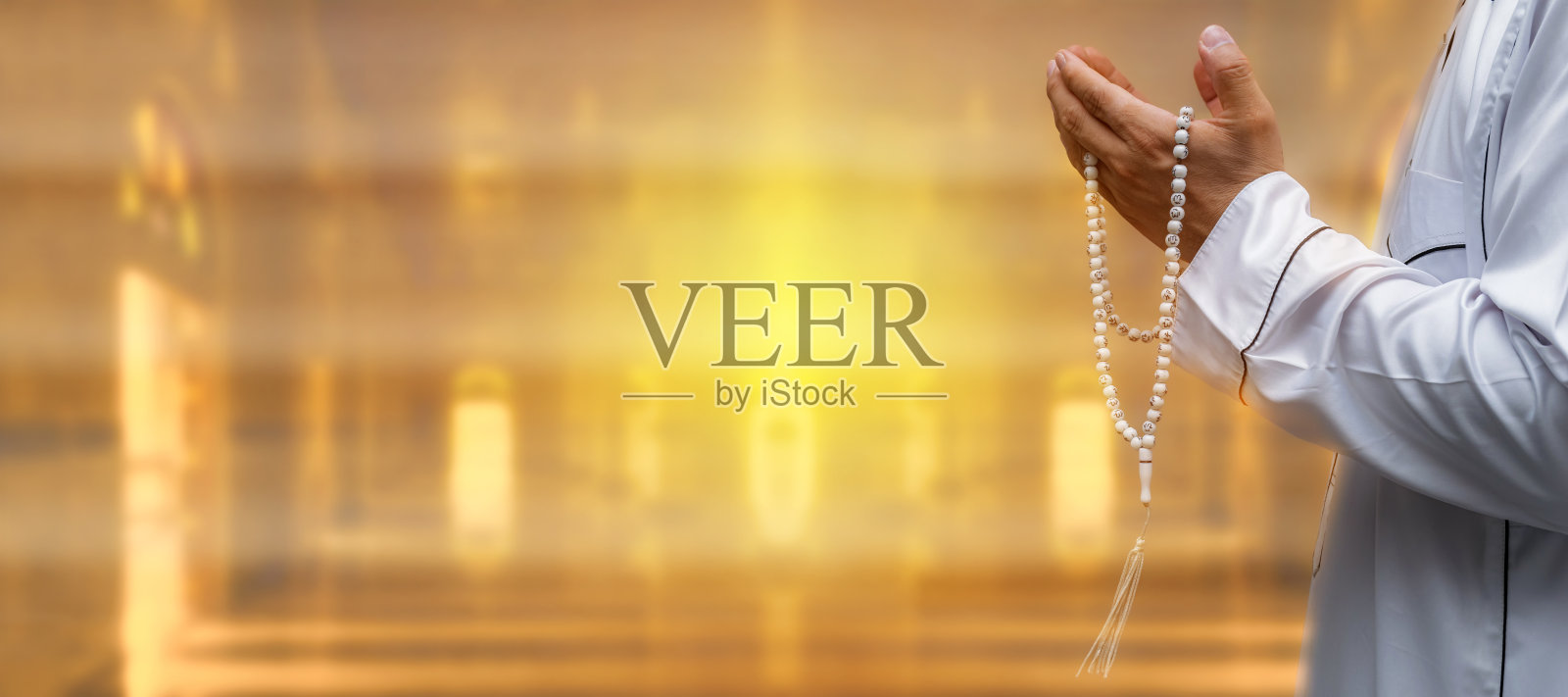 一名穆斯林男子在清真寺内举起双手和塔斯比一起祈祷。关注手。虔诚的亚洲穆斯林男子在祈祷。禁食的结束。开斋节。照片摄影图片