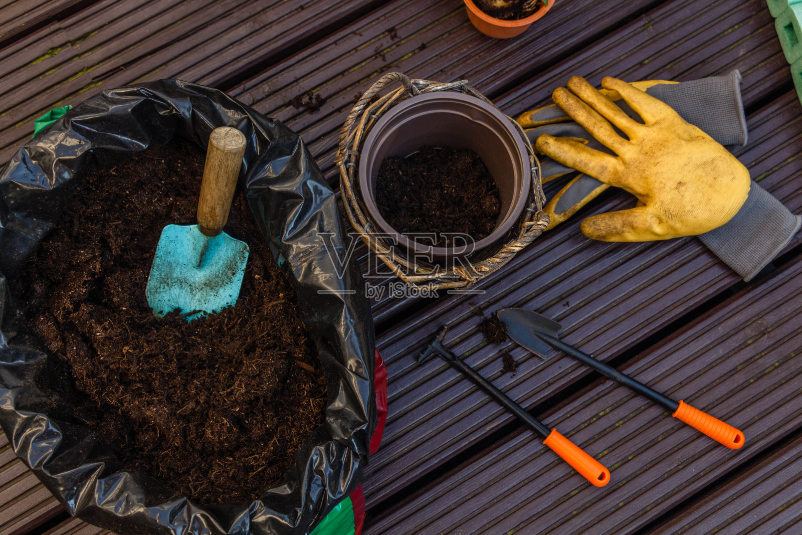 近距离堆肥，园艺设备和手套种植在露台上照片摄影图片