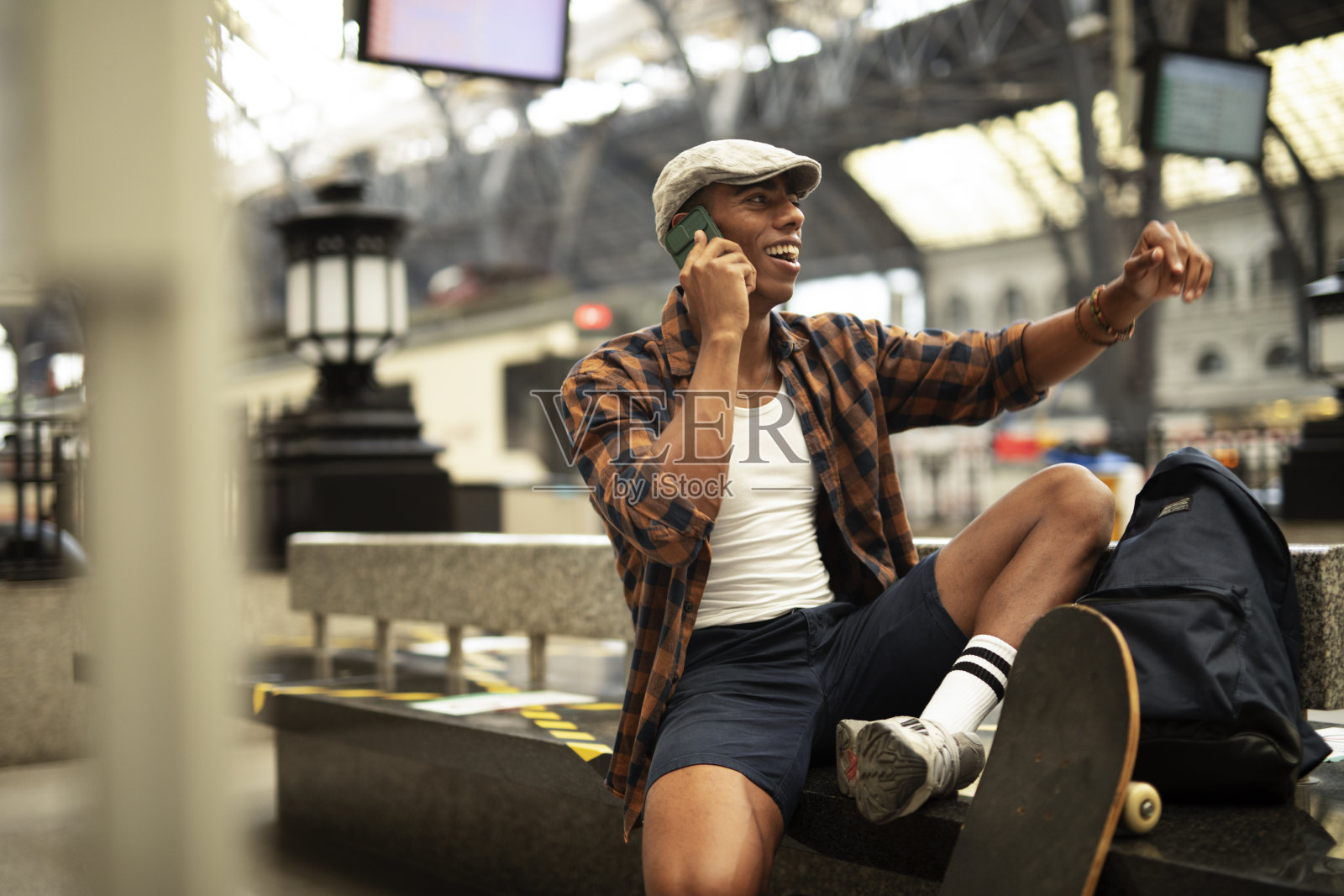 快乐的年轻人在等火车。照片摄影图片