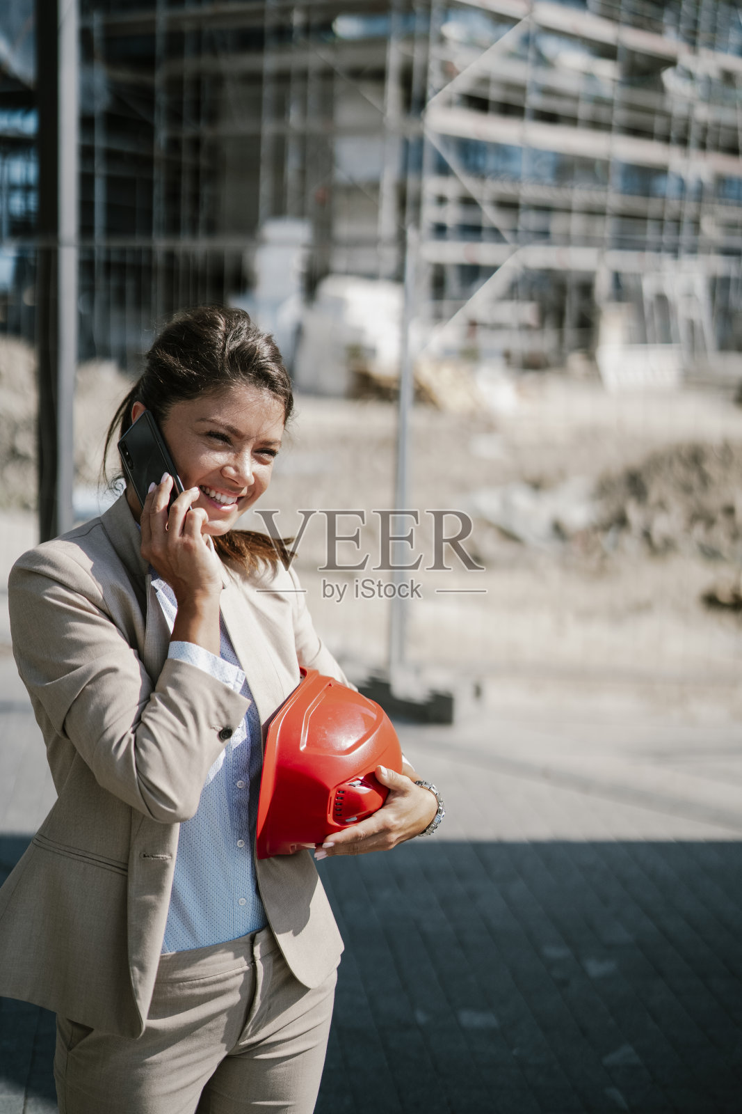 年轻漂亮的建筑师正在打电话。照片摄影图片