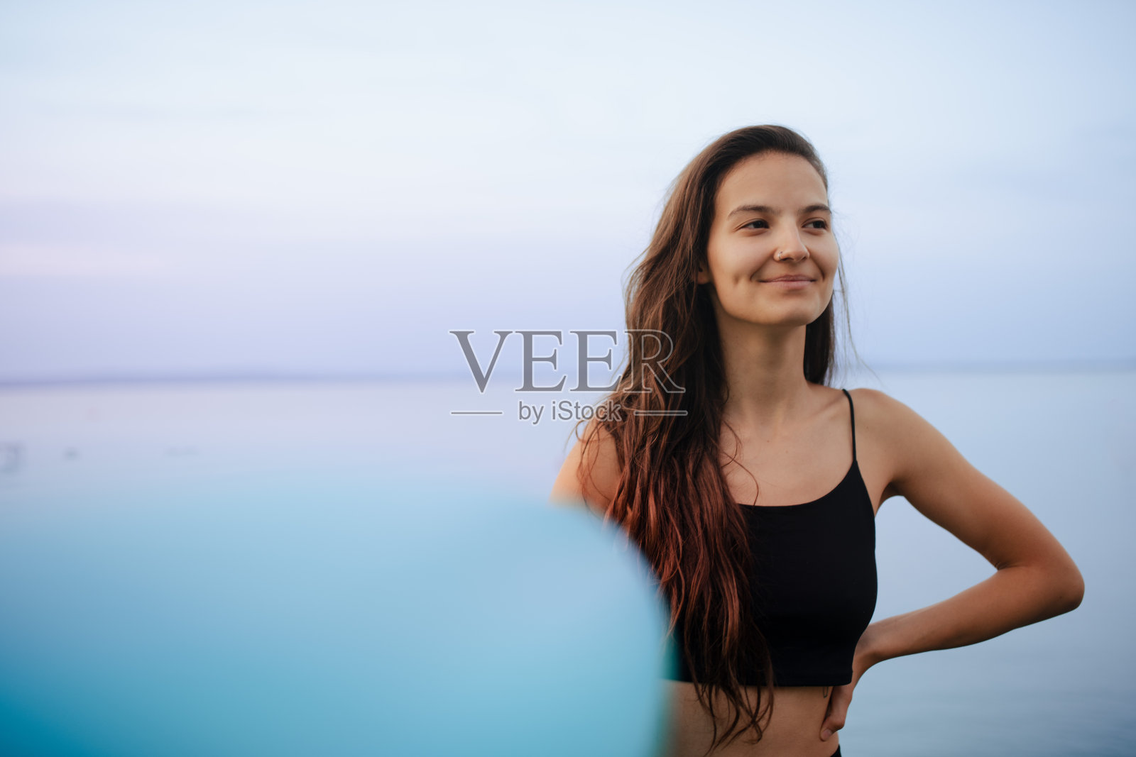 年轻美丽的运动女孩与冲浪板在湖上日出照片摄影图片