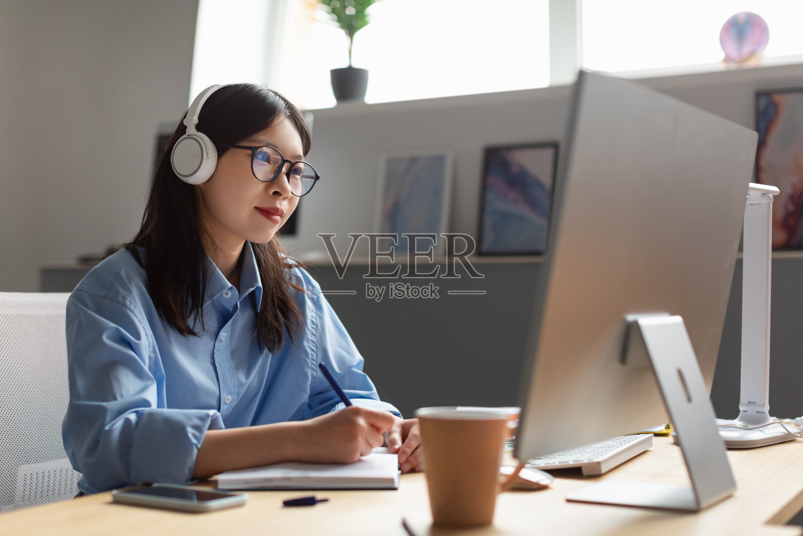 亚洲女商人在办公室用电脑做笔记照片摄影图片