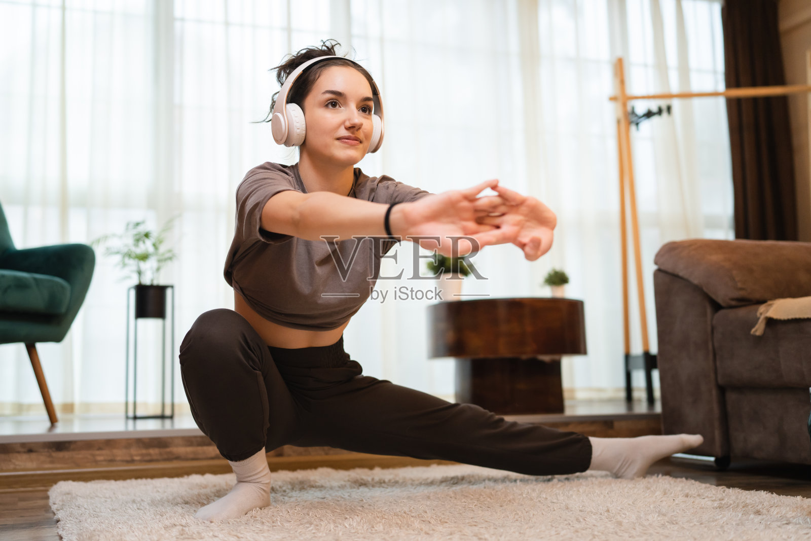 一名女子在家训练，年轻的成年女性在地板上伸展照片摄影图片
