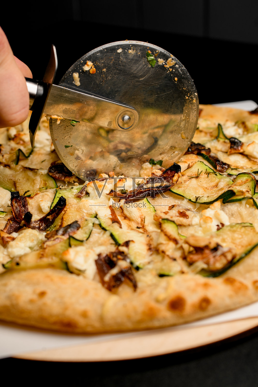 选择性专注于切披萨刀，切出美味的素食披萨照片摄影图片