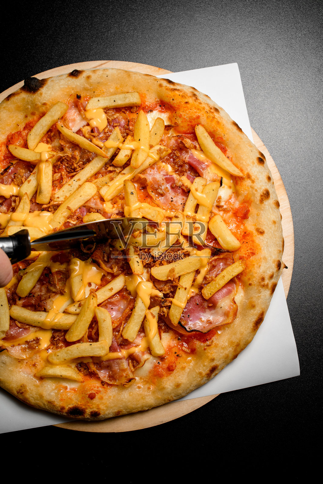 俯视图热披萨，炸薯条和培根片，用披萨刀切照片摄影图片