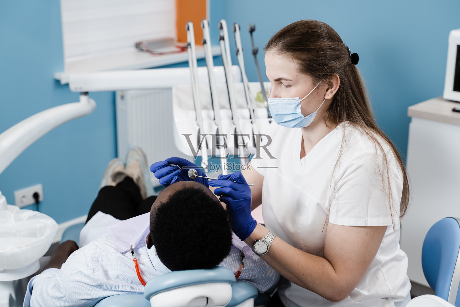 牙医为非洲男子检查牙齿治疗牙痛。牙痛。与牙科医生会诊。照片摄影图片