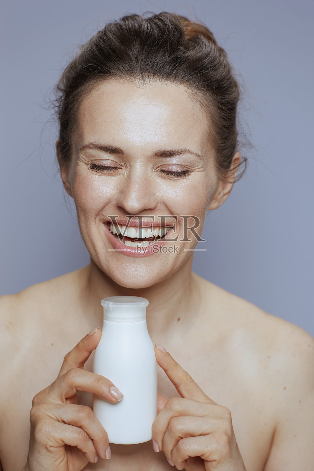 微笑的年轻女子化妆膏罐上的蓝色照片摄影图片