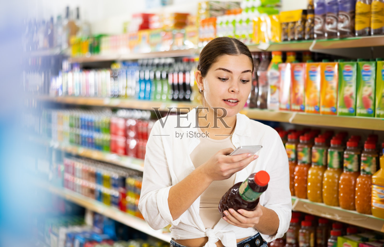 年轻女子在超市网上搜索果汁信息照片摄影图片