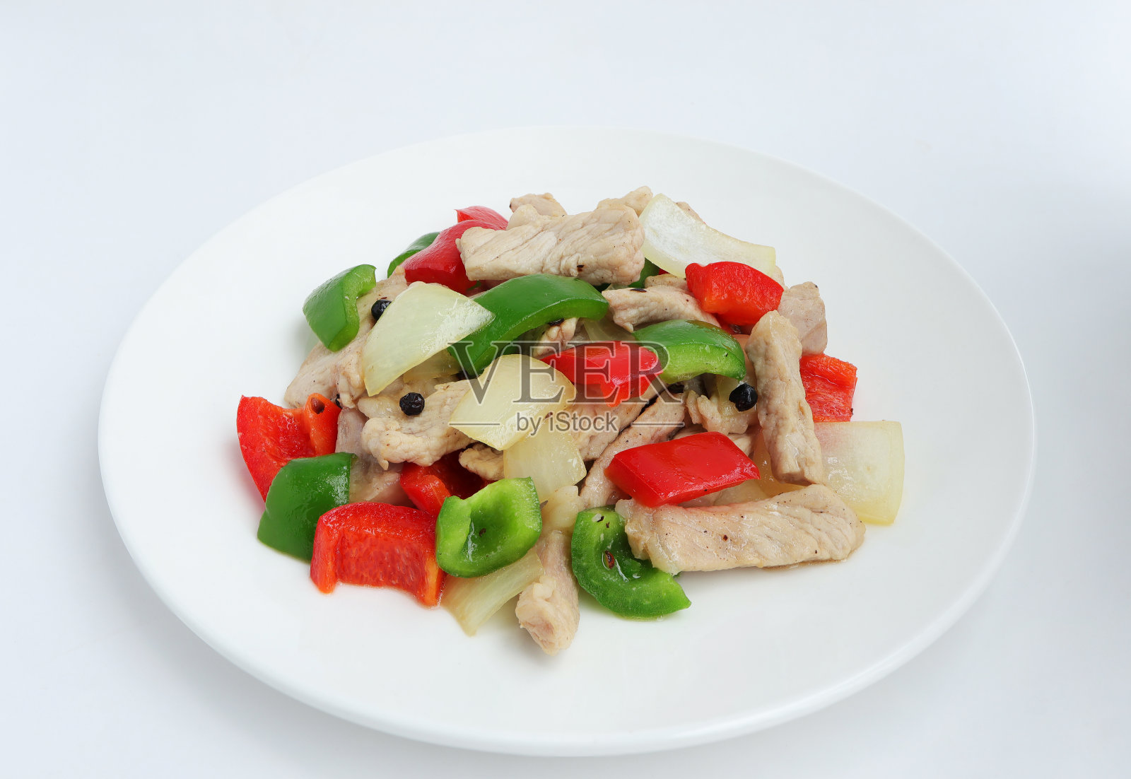 美味的自制白碟炒猪肉，加甜椒、洋葱和黑胡椒。俯视图，白色背景。照片摄影图片