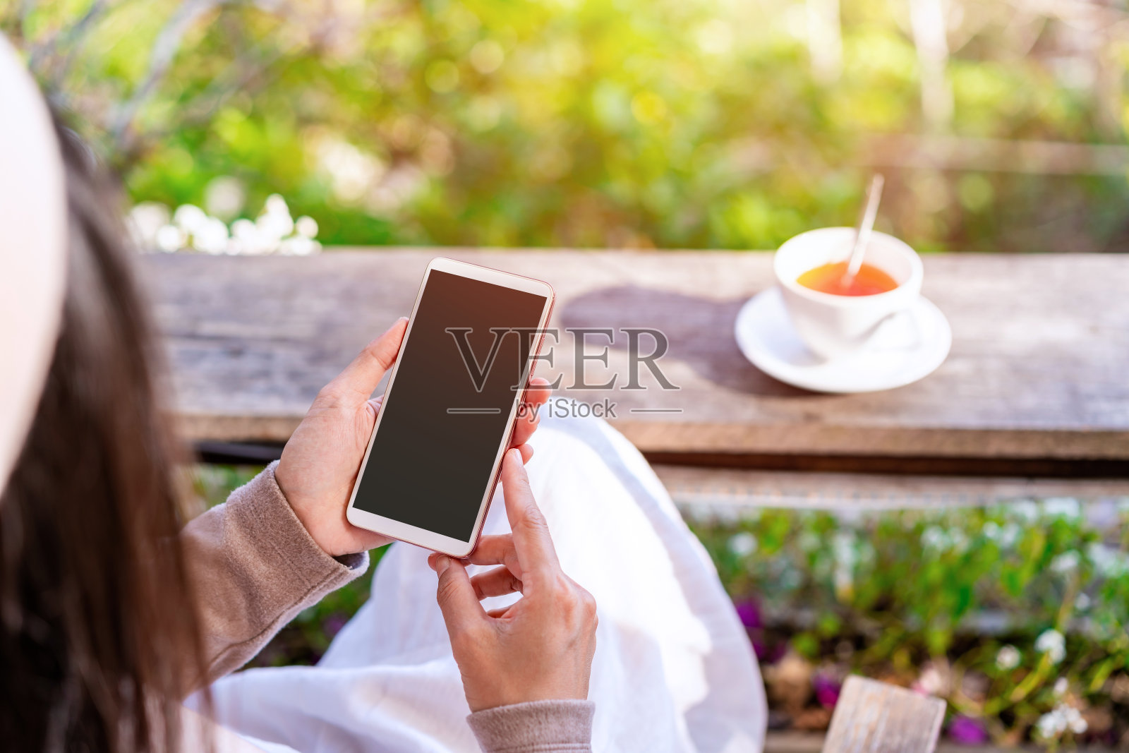 年轻女性用手机喝咖啡，在咖啡馆放松，现代生活方式照片摄影图片