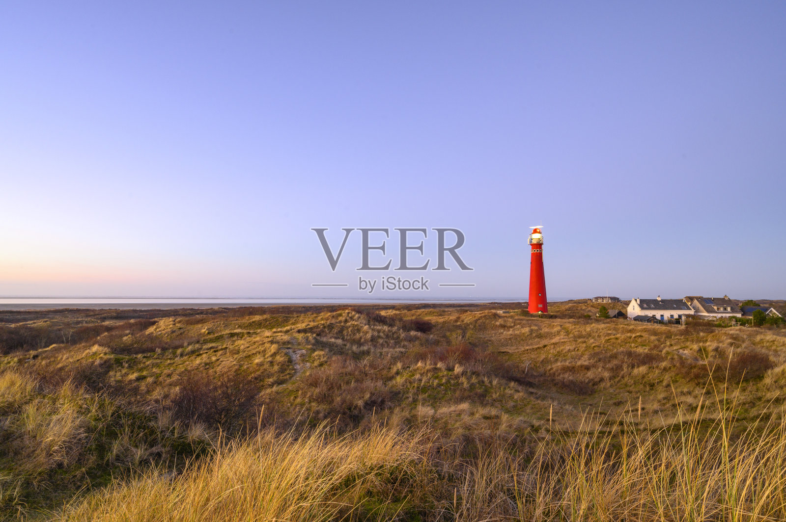 Schiermonnikoog沙丘全景与日落时的灯塔照片摄影图片