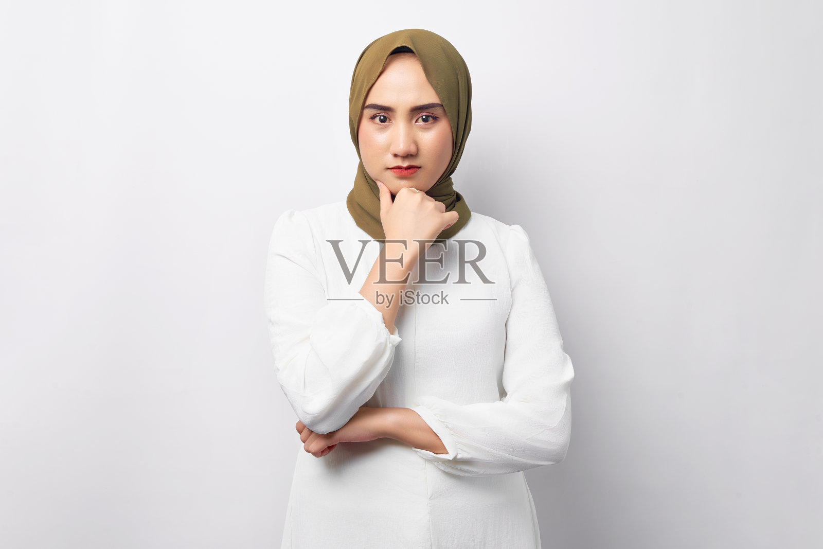 美丽沉思年轻的阿拉伯亚洲穆斯林妇女戴着头巾触摸她的下巴，看着相机孤立在白色背景。人们宗教生活方式观念照片摄影图片