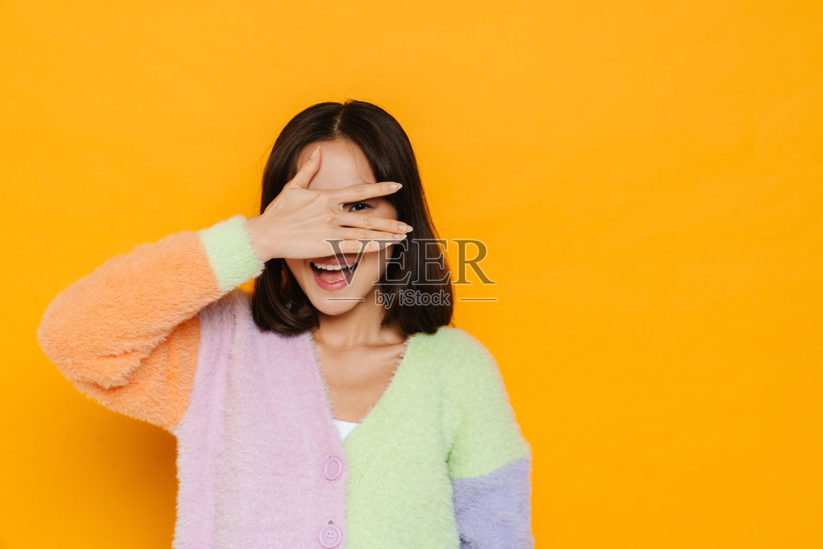 亚洲年轻女子穿着毛衣笑着遮住眼睛照片摄影图片