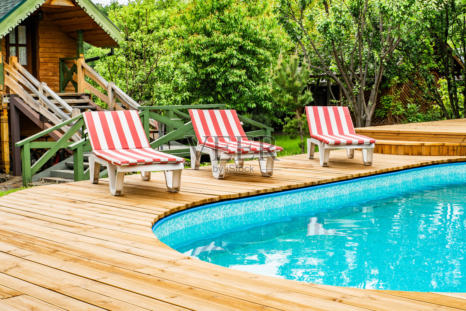 在一个温暖的夏日，泳池边的日光浴床。休息时间照片摄影图片