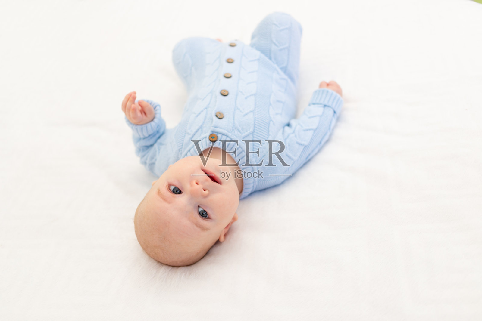 小男孩在床上。儿童纺织品和床上用品。婴儿的早晨照片摄影图片