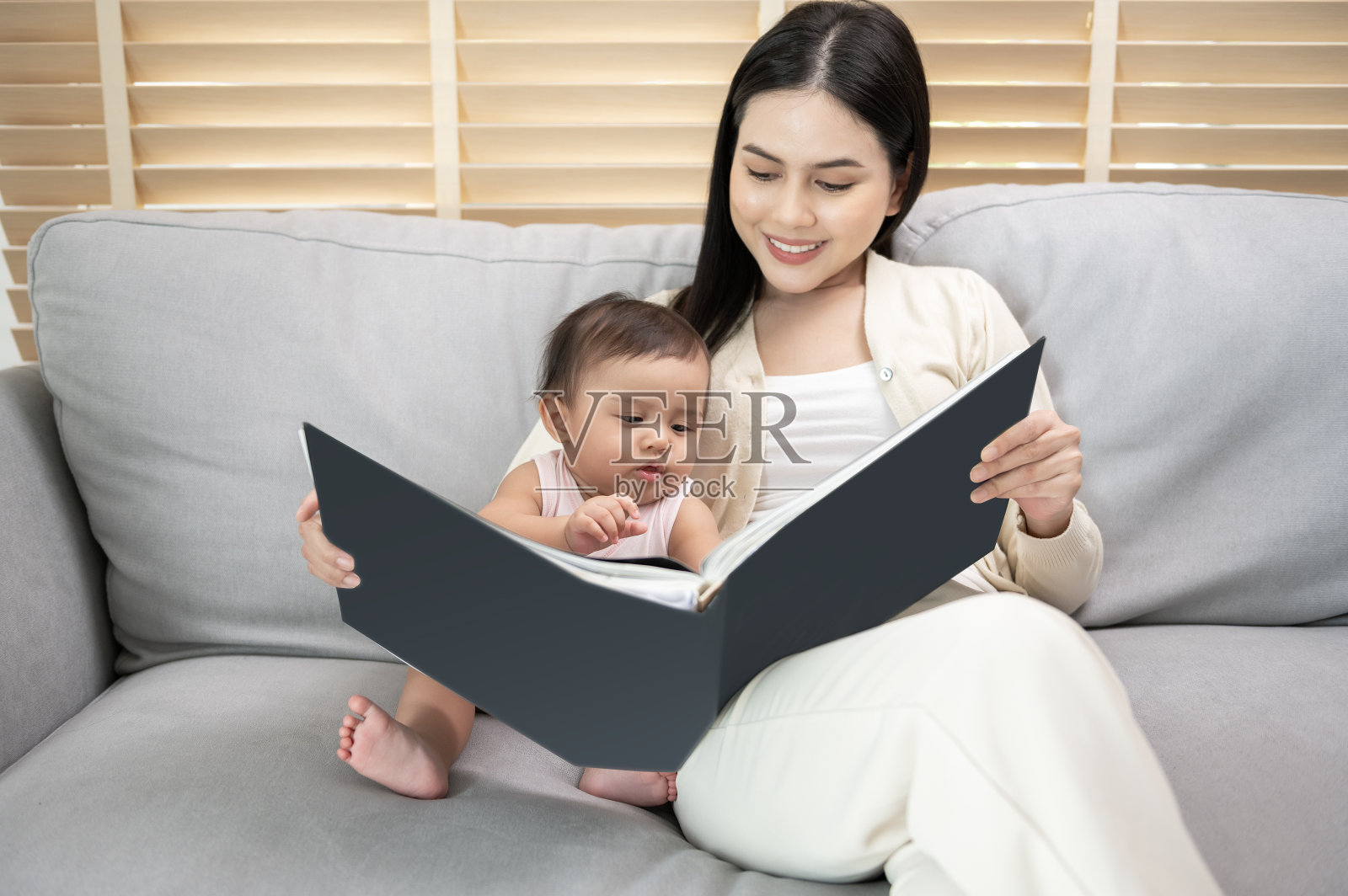 美丽的妈妈在家里给女儿读书照片摄影图片