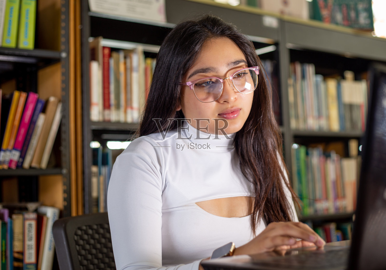 女孩在图书馆做作业照片摄影图片