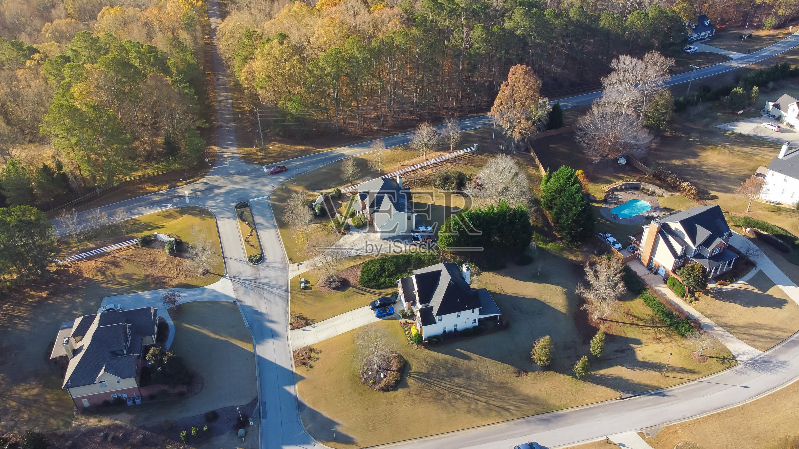 公园边的房子在郁郁葱葱的地区，有秋天的树叶，低密度的住宅两层楼，游泳池，修剪整齐，没有围栏的院子，美国佐治亚州亚特兰大郊区照片摄影图片