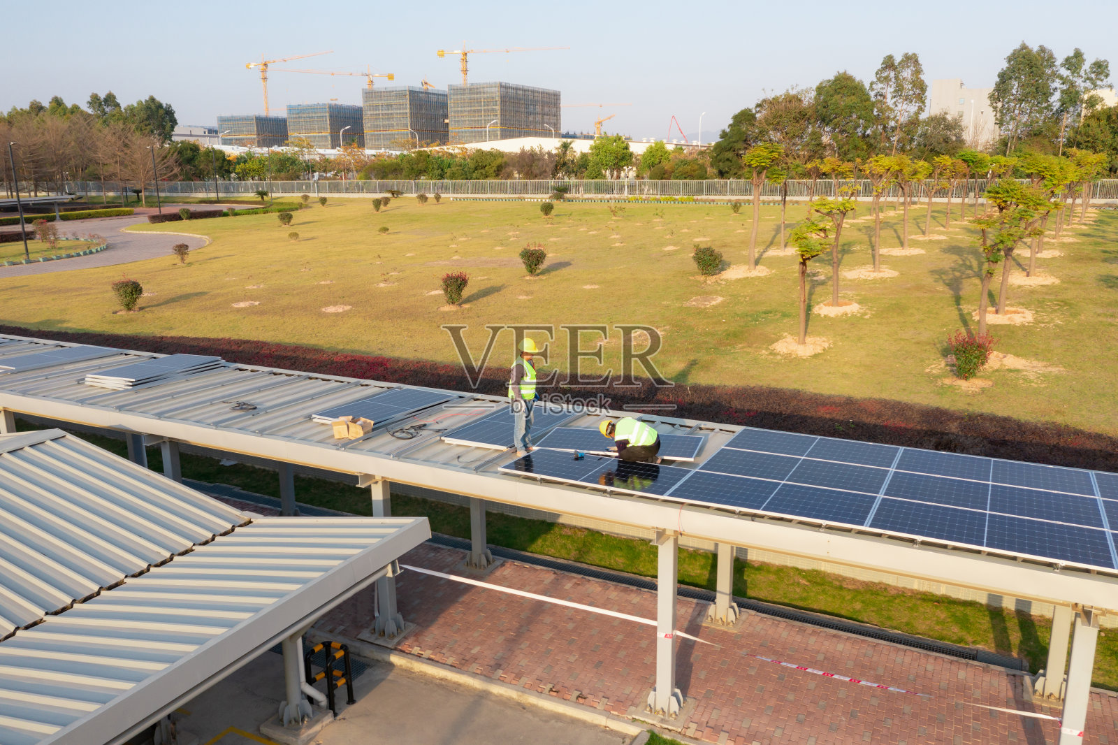 工人们正在走廊的屋顶上安装太阳能电池板照片摄影图片