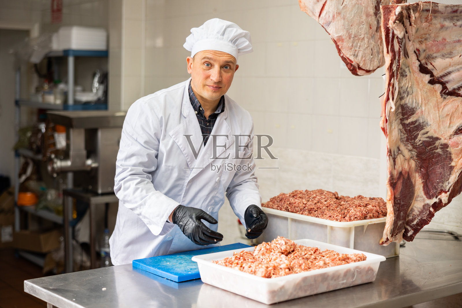 阳性男性屠夫正在肉铺做碎牛肉照片摄影图片