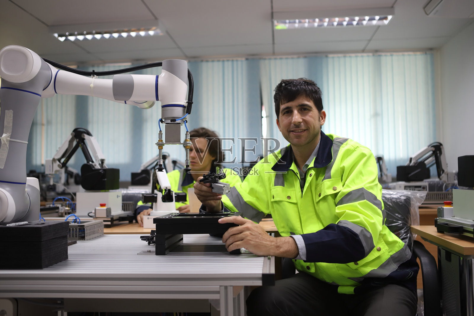 工程师教授机器人焊机，讲解机械臂如何工作，所有功能均由远程控制照片摄影图片