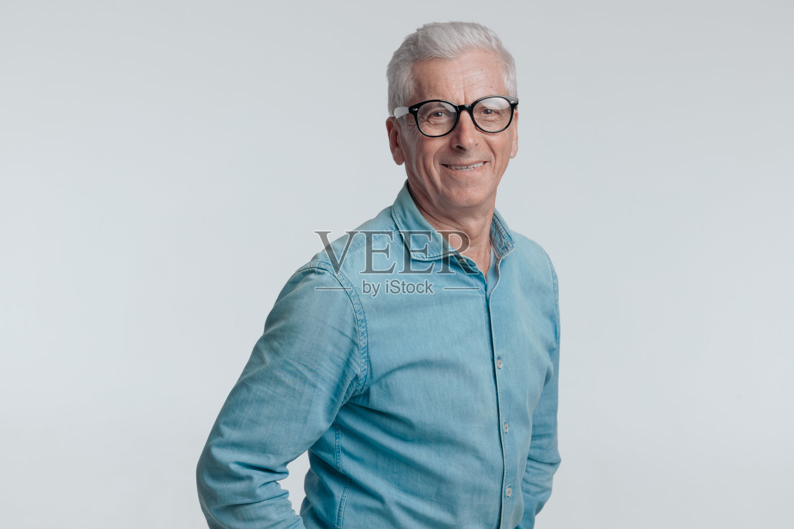 60多岁的快乐男子在灰色背景上微笑和摆姿势的肖像照片摄影图片