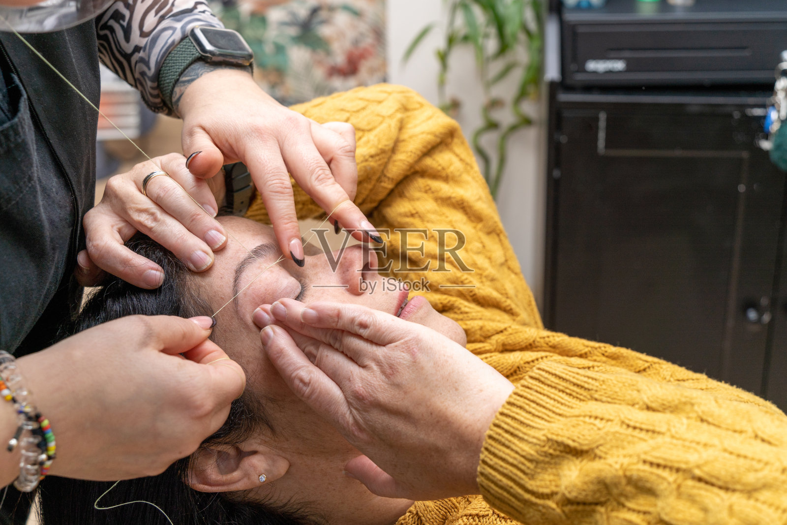 病人协助眉妆师穿线照片摄影图片