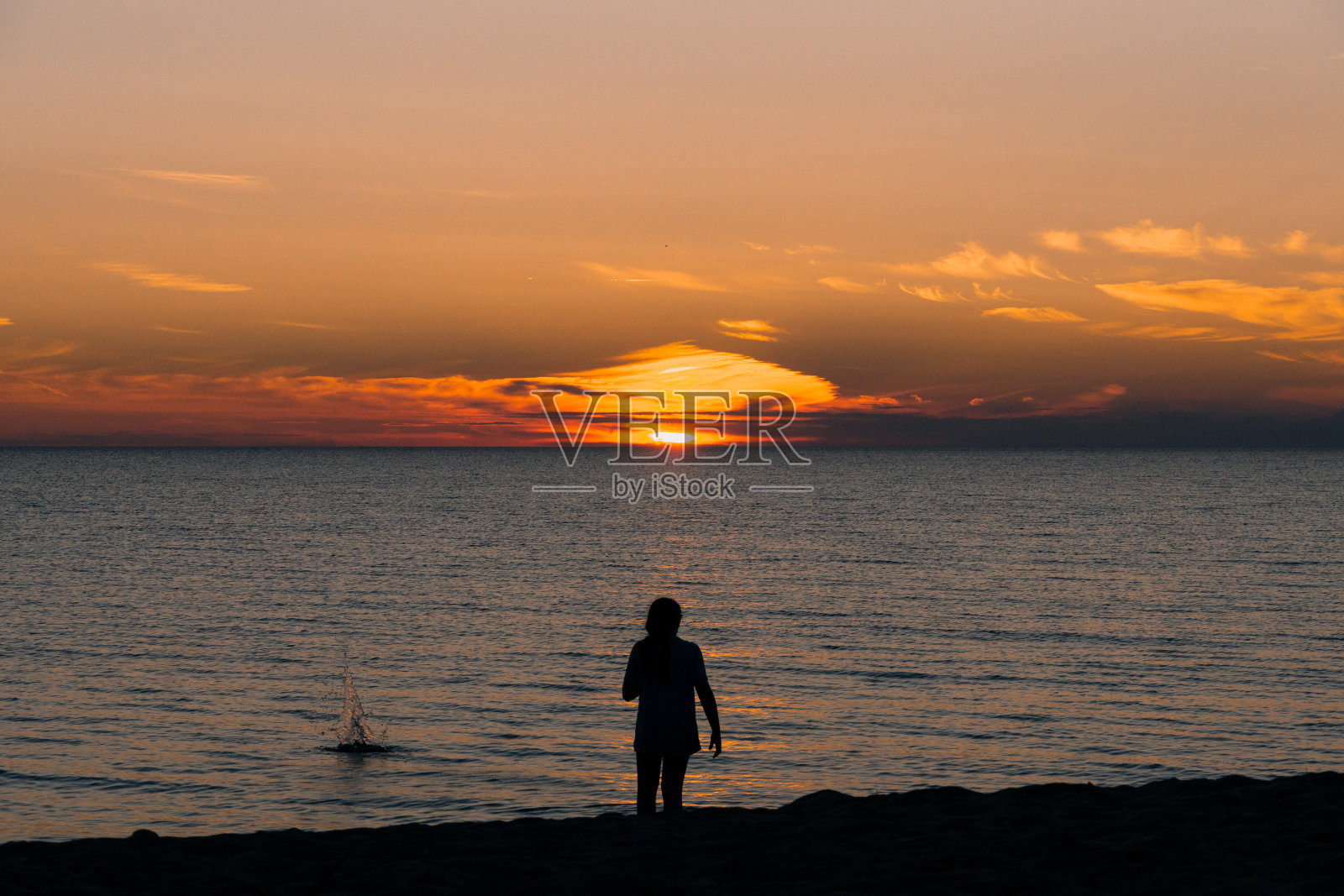 在海滩上跳石头照片摄影图片