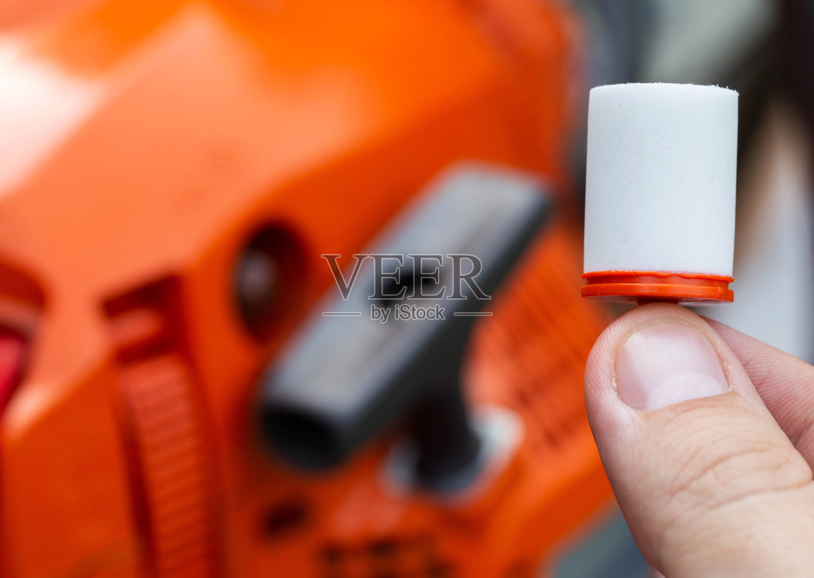 新燃料过滤器的背景上的一个链锯。更换燃油滤清器的概念，保护发动机不受燃油中的杂质、水和污垢的影响。特写镜头照片摄影图片