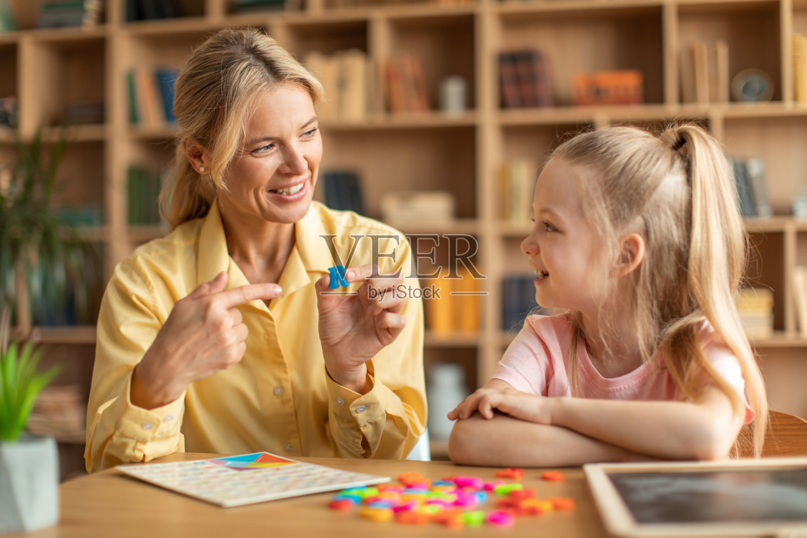 快乐的女语言治疗师在个人训练中教发音有缺陷的小女孩说R音照片摄影图片