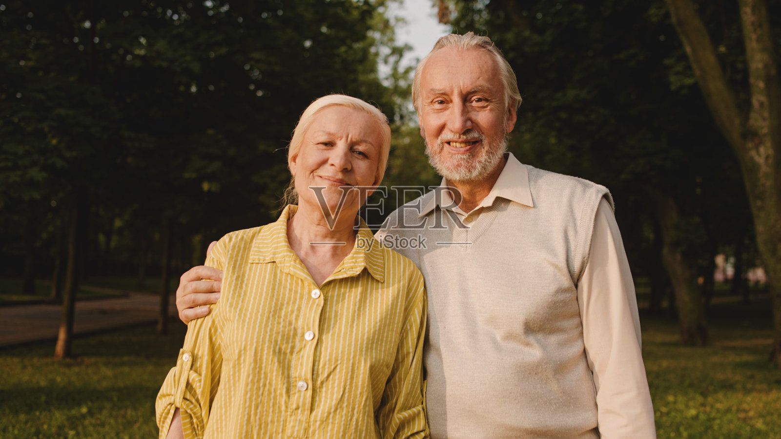 白发苍苍的夫妻在户外对着镜头微笑，幸福的退休，相爱照片摄影图片