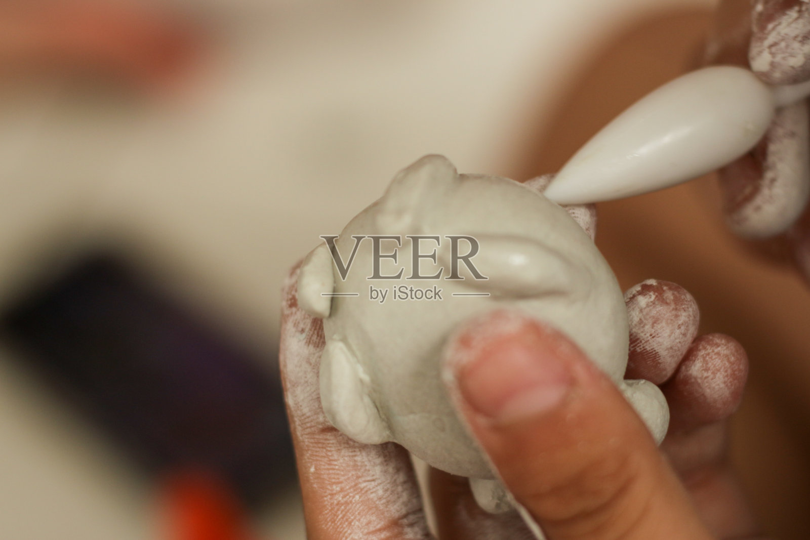 塑造凹痕的女孩将用她的工具，孩子们的创造力，用她自己的双手，制作一个轻盈的橡皮泥雕塑。教育的概念。照片摄影图片