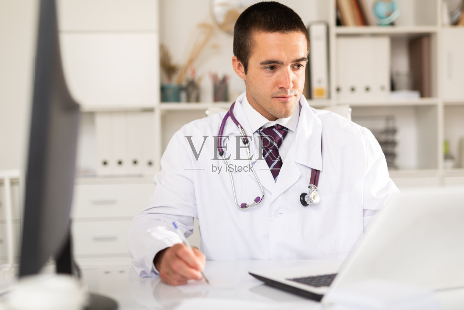 开朗的男人医生在办公室有效地工作照片摄影图片