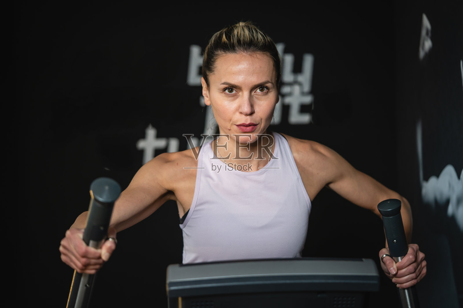 一个成熟的白人妇女在椭圆交叉训练器上锻炼照片摄影图片