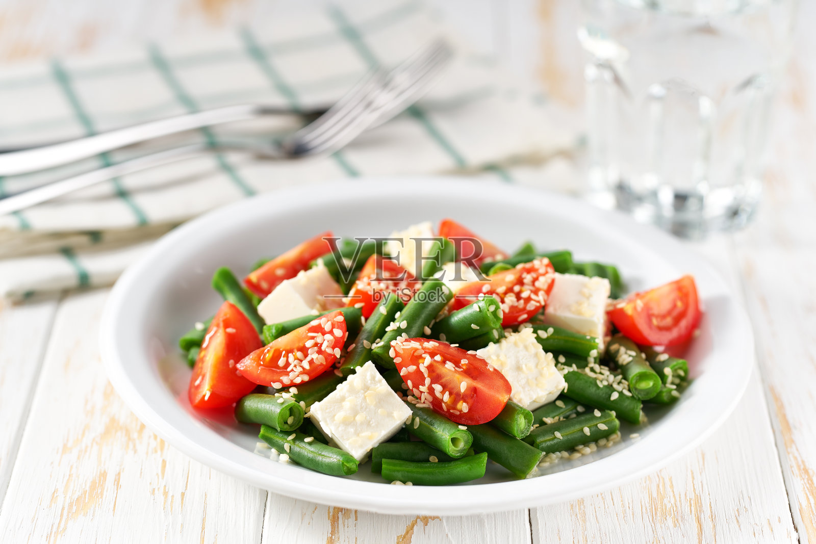 青豆沙拉配番茄，羊乳酪和芝麻。照片摄影图片
