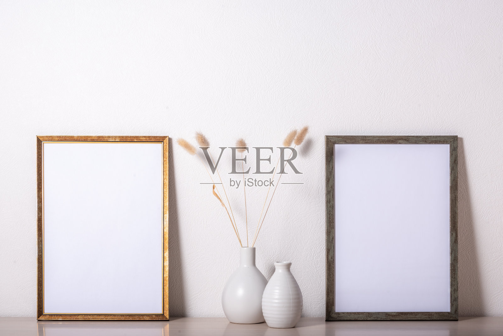 模板和相框放在木桌上。Lagurus的花束。照片摄影图片