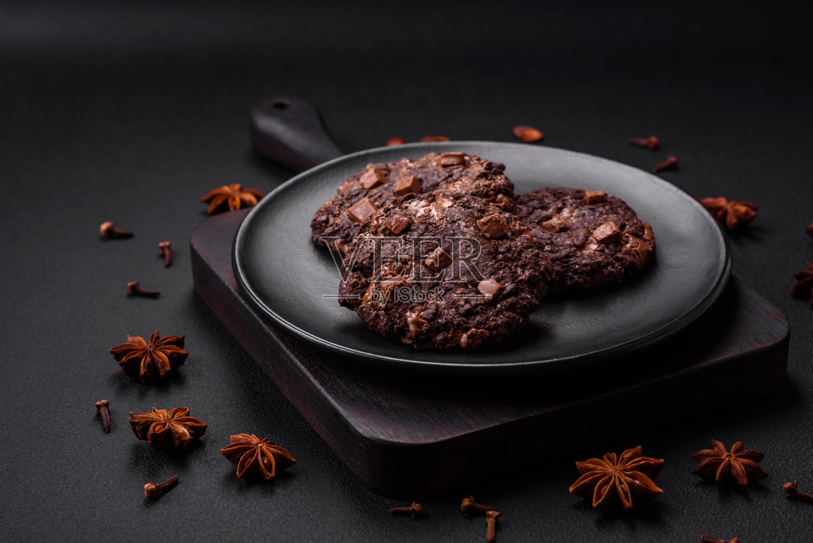 美味的巧克力燕麦圆饼干放在黑色的陶瓷盘子里照片摄影图片