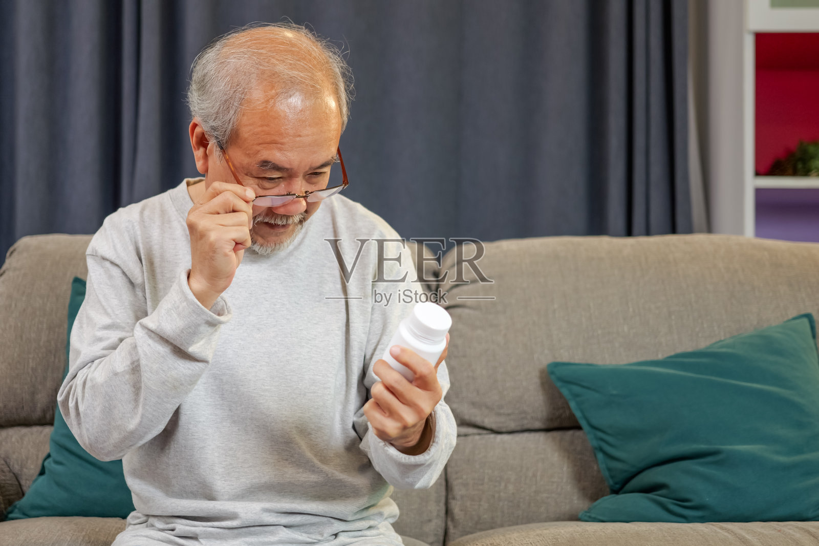 照顾老人的护士坐在家里的沙发上照顾老人照片摄影图片