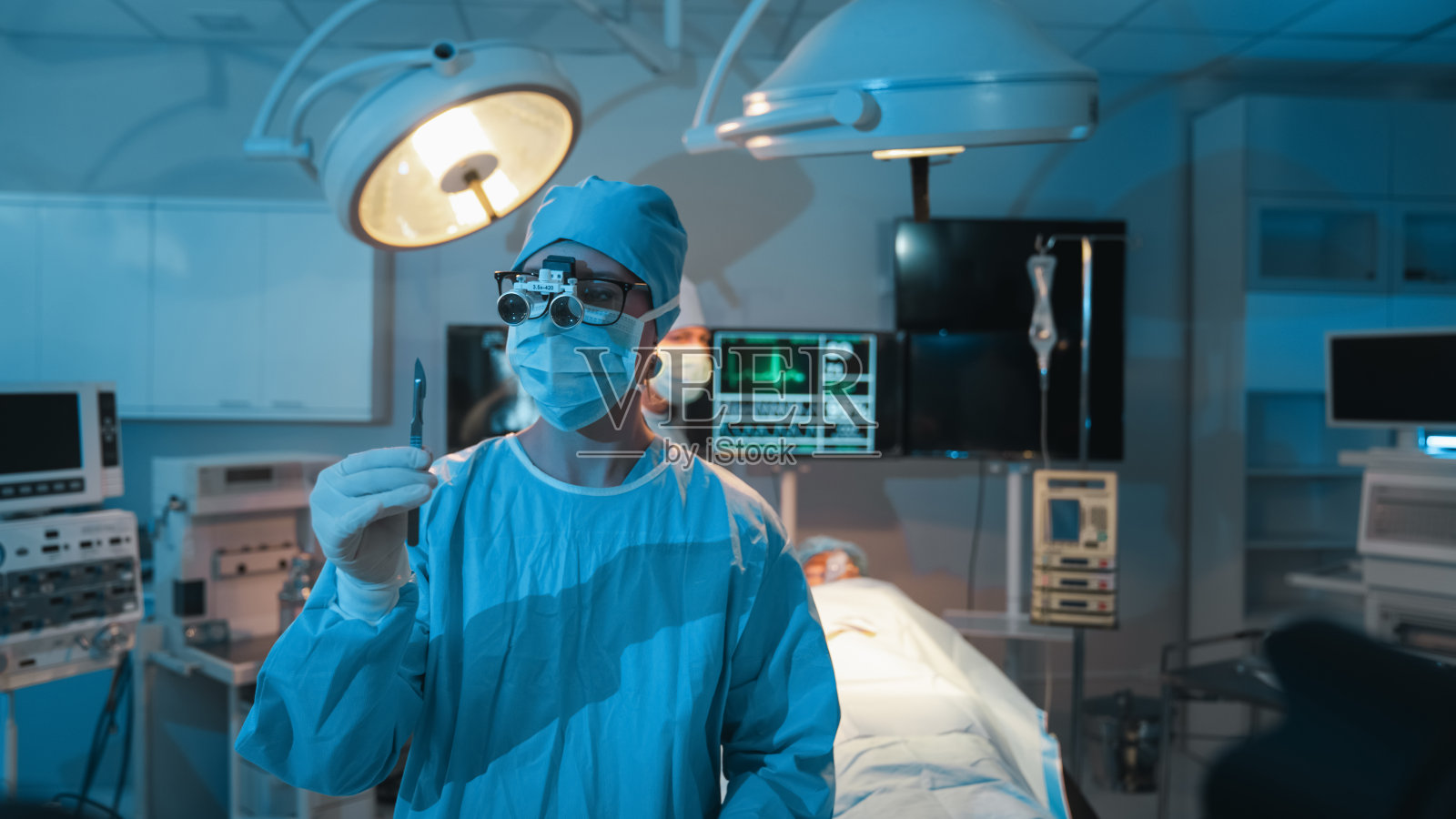 在进行手术之前，医疗小组与病人讨论了手术方案。外科医生在医院的手术室里给病人做手术照片摄影图片