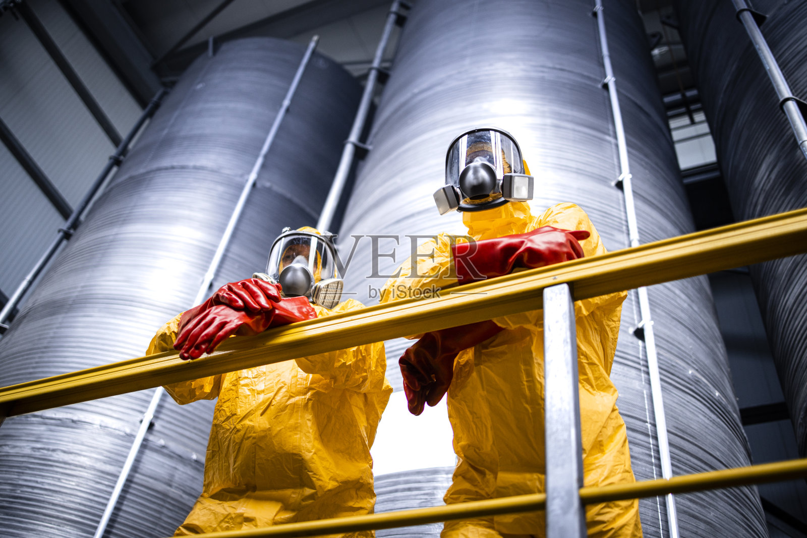 化工厂内部，工人戴着防毒面具。照片摄影图片