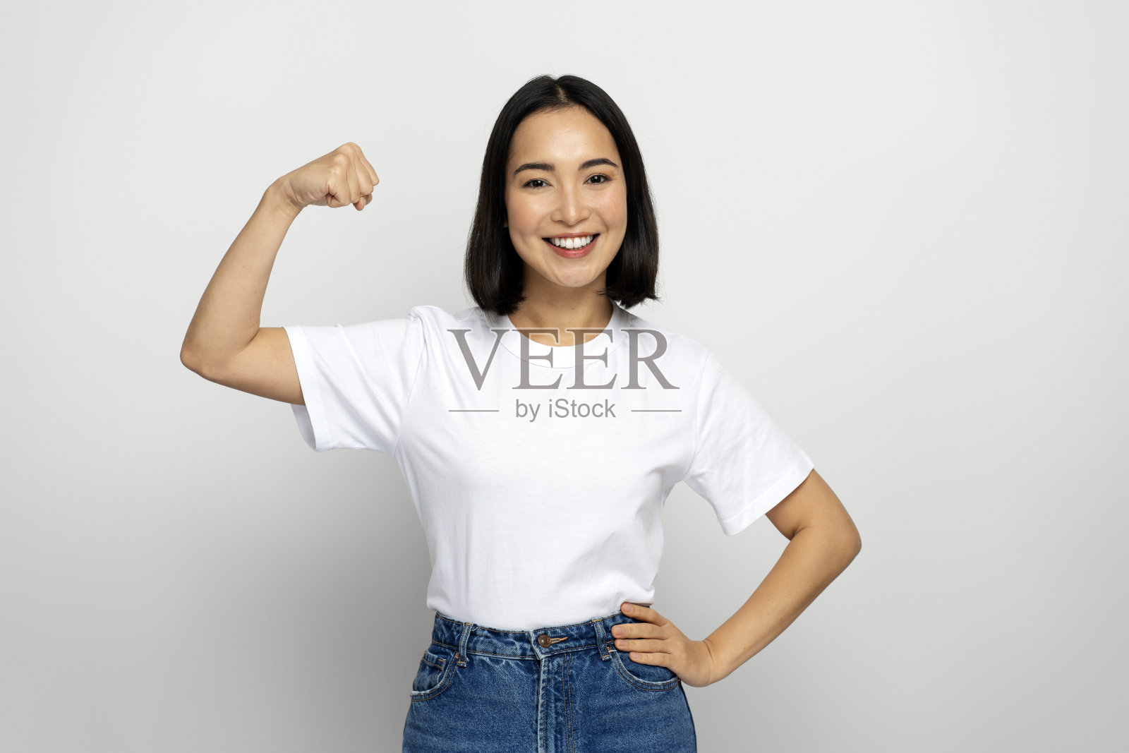 女性举起手臂展示二头肌的肖像，作为女性力量的隐喻照片摄影图片