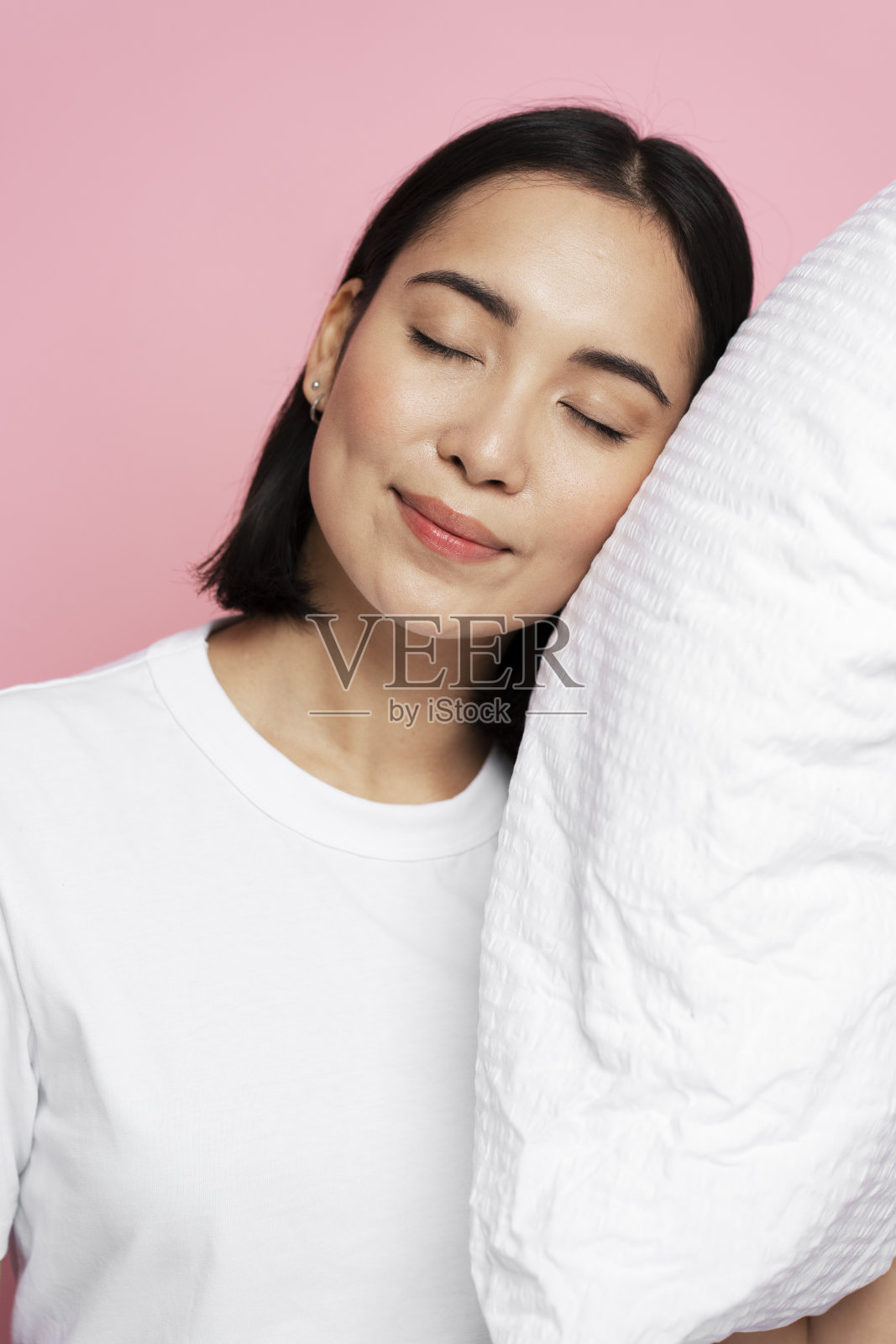 照片肖像的华丽女孩抱枕头闭着眼睛孤立的粉红色照片摄影图片