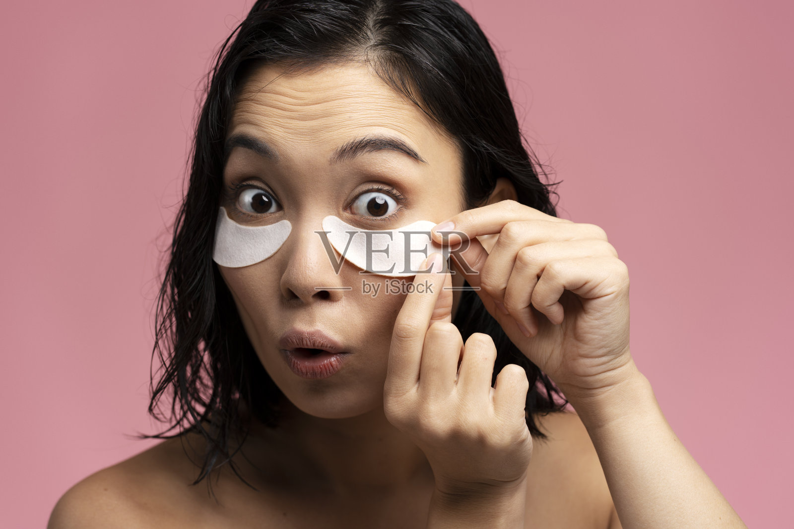 有趣的年轻女子应用胶原蛋白补丁进行美容治疗照片摄影图片