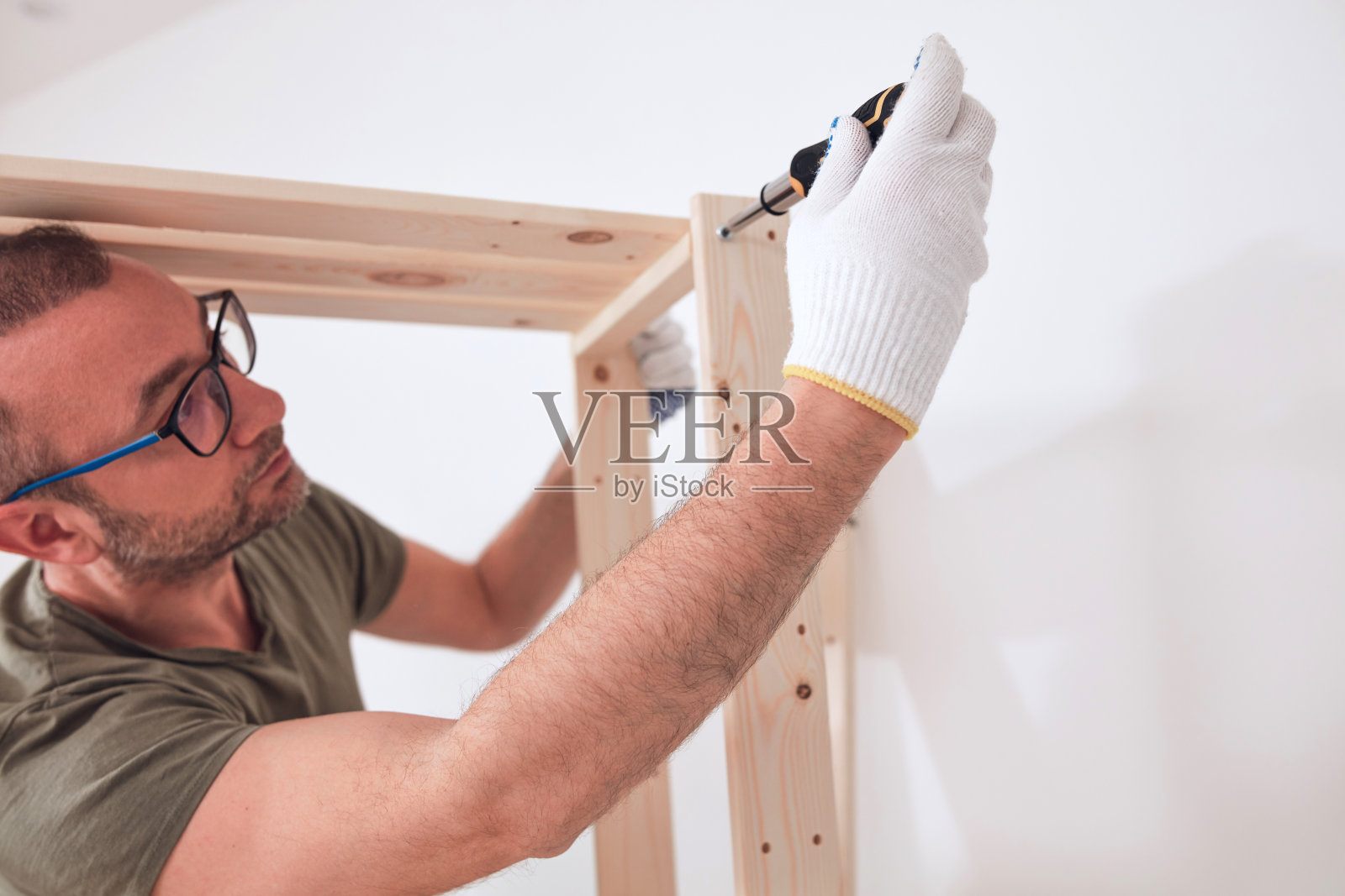 男子在公寓里组装新的木架和家具。照片摄影图片